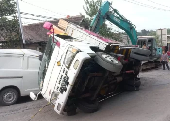 truk bermuatan triplek terguling